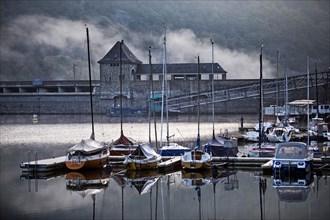 Eder dam with dam wall and pleasure boats on the Edersee in the early morning