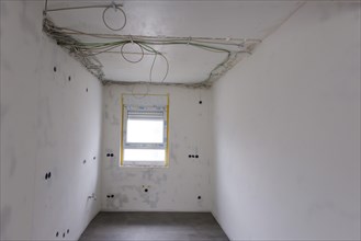 Room with newly laid electrical cables under the ceiling