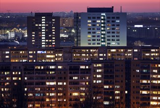 View in the evening at blue hour of high-rise buildings and apartment blocks with rental flats and condominiums in the Berlin district of Marzahn-Hellersdorf