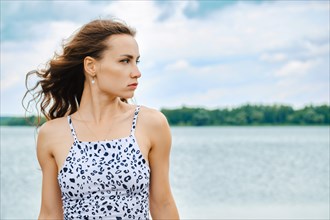 Portrait of beautiful woman looking away at lake