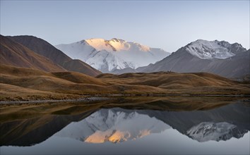 Mountain landscape at sunset, mountains reflected in a small mountain lake, Pik Lenin, Trans Alay