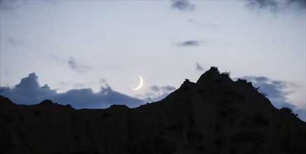 Moon in front of a mountain silhouette, Konorchek Canyon, Chuy, Kyrgyzstan, Asia