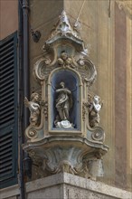 Veneration of the Virgin Mary with angel figures on a corner house, in the historic centre, Genoa,