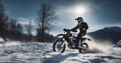 Motocross on an enduro motorcycle in the snow in winter, a motorcyclist in equipment and a helmet