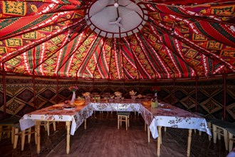 Set table and chairs in a colourful yurt, yurt with traditional patterns, Naryn region, Kyrgyzstan,