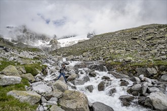 Mountaineers photographed, at a mountain stream, Furtschaglbach, behind rocky mountains with