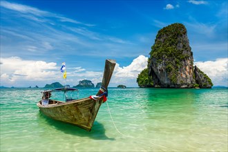 Long tail boat on tropical beach (Pranang beach) and rock, Krabi, Thailand, Asia