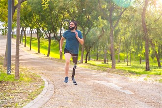 Sportsman with a artificial leg running along a path in an urban park
