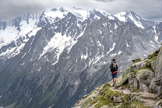 Mountaineer on hiking trail, glaciated rocky mountain peaks Hoher Weisszint, Berliner Hoehenweg,