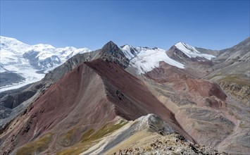 Mountain landscape of glacial moraines, mountains with red and yellow rocks, glaciated mountains in