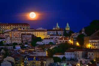 Beautiful view of big full moon over Lisbon areas of Sao Vincente de Fora church, Sao Jorge castle