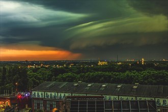 Dramatic sky with impressive storm clouds over a city at dusk, Duisburg, North Rhine-Westphalia,