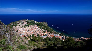 Panoramic view of a picturesque coastal town with historic architecture on the edge of the azure