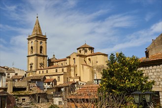 View over the roofs of an old town with church and trees under a blue sky, Novara di Sicilia,