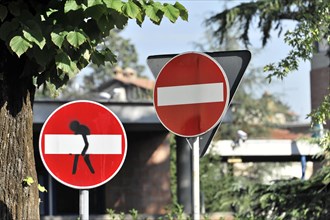 Street signs, with figure modified no entry sign, centre, Assisi, Umbria, Italy, Europe