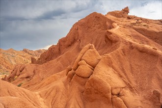 Eroded mountain landscape, sandstone cliffs, canyon with red and orange rock formations, Konorchek