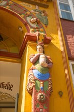 Historic Old Ratsapotheke in the old town, decorative entrance, colourful coats of arms and figures