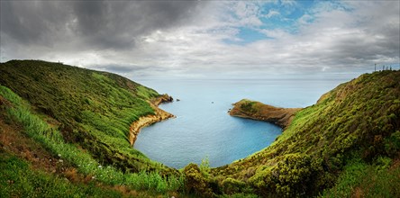 Panoramic view from Monte da Guia over a green coastline and bay on a cloudy day, Monte da Guia,
