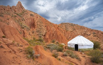 Yurt between eroded mountain landscape, sandstone rocks, canyon with red and orange rock