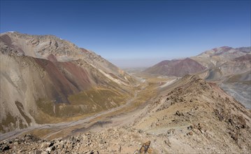 Mountain landscape of glacial moraines, mountains with red and yellow rocks, Traveller's Pass below