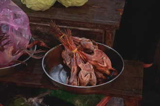 Raw native poultry meat arranged in a metal bowl at a local market showing the candid khmer daily
