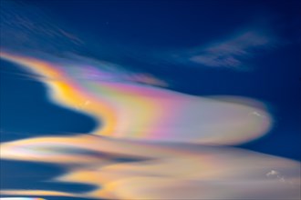 Beautiful Colorful Rainbow Clouds (Cloud Iridescence) Against Blue Sky in a Sunny Day with Light