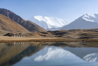 Yurts, mountains reflected in a small mountain lake, Pik Lenin, Trans Alay Mountains, Pamir