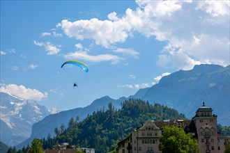 Paragliding in front Of Snow Capped Jungfraujoch Mountain in a Sunny Day in Interlaken, Bernese