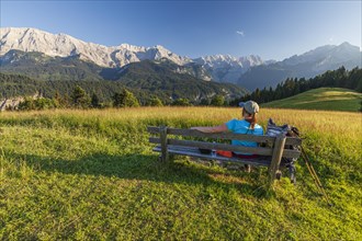 Hiker sitting on a bench in front of mountains, woman, summer, afternoon, Eckbauer,