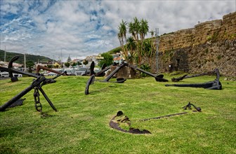 Old anchors lie on a green meadow in an open-air museum of maritime history, Horta, Faial Island,
