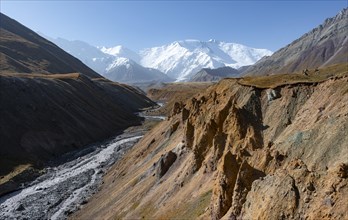 Achik Tash river, Achik Tash valley with rock formations, behind glaciated and snow-covered