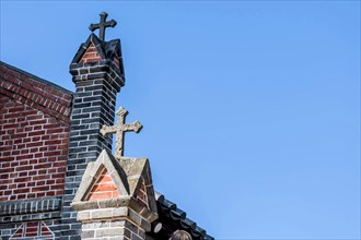 Christian crosses on roof of red brick catholic church