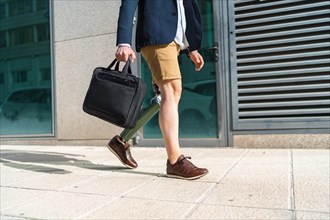 Lower part of an unrecognizable man with shorts and prosthetic leg walking along a financial