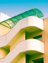Low angle view of building with outside concrete staircase covered by green awning