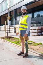 Vertical portrait of an employee with prosthetic leg working on construction site wearing
