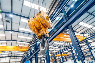Low angle view photo of an industrial crane in a logistics factory