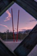 View through a frame of a red sculpture against a twilight sky, Enzauen Park, Pforzheim, Germany,
