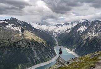 Mountaineer on a rock in front of a mountain panorama, view of Schlegeisspeicher, glaciated rocky