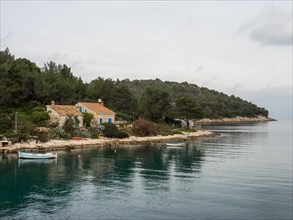 View from the promenade path to a small house by the sea, near Veli Losinj, Kvarner Bay, Croatia,