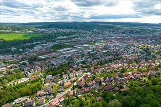 Aerial view of a city with dense buildings, surrounded by green areas and a cloudy sky, Pforzheim,
