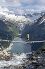 Mountaineers on a suspension bridge over a mountain stream Alelebach, picturesque mountain