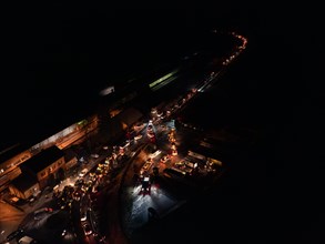 Night view of an illuminated road full of tractors and people, farmers protest, Black Forest, Bad