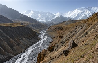 Achik Tash river, Achik Tash valley with rock formations, behind glaciated and snow-covered
