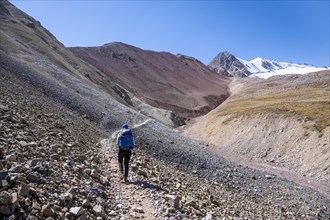 Barren high mountains, hiker on the hiking trail to the base camp of Lenin Peak, Osh Province,