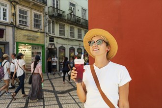 Happy woman drinking tea in beautiful town, coimbra