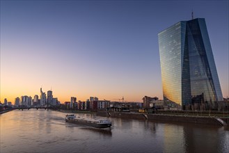 A ship sails past the European Central Bank (ECB) on the Main River in the evening, Frankfurt am