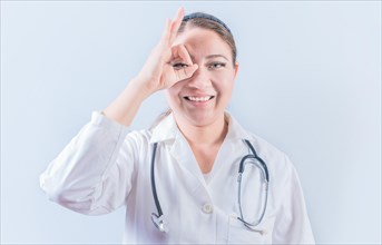 Young female doctor approving with finger on isolated background. Cheerful female doctor gesturing