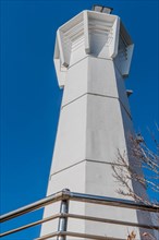 Low angle view of white lighthouse against clear blue sky