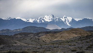 Mountain landscape with snow-covered peaks behind a desert-like plain, Kyrgyzstan, Asia