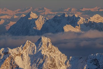 Mountain peak in the snow in the evening light, high fog, distant view, view from Zugspitze to